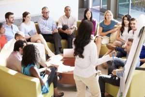 Diverse group in a business meeting with presenter.