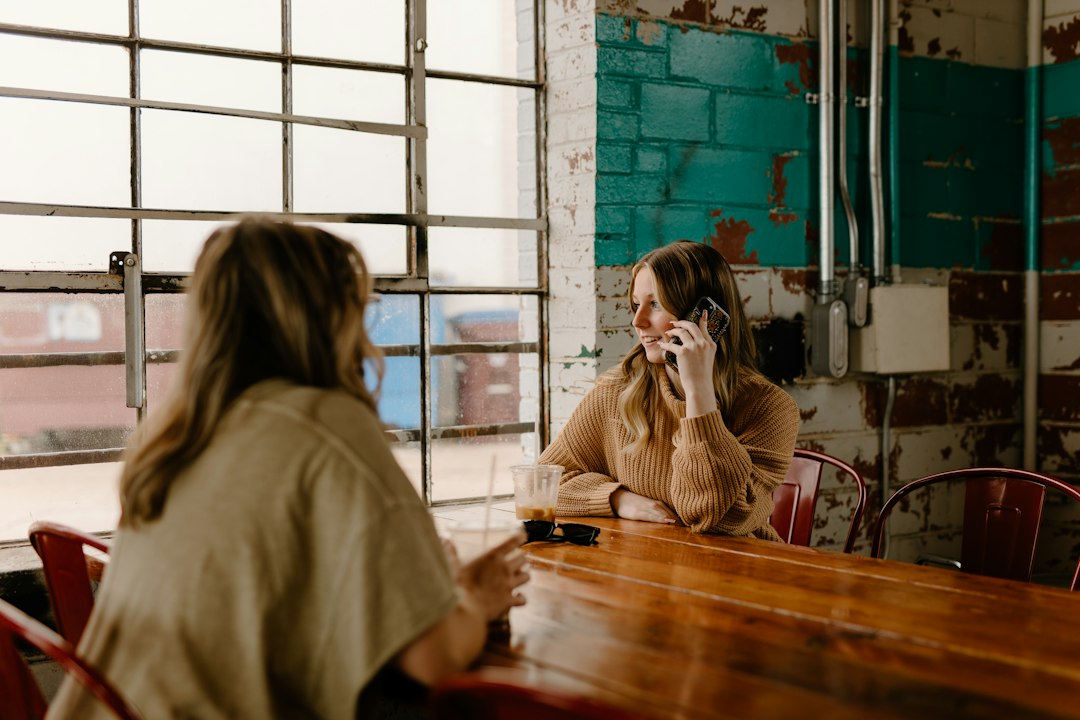 Adult using a phone in a calm setting, illustrating access to crisis support and follow-up connection.