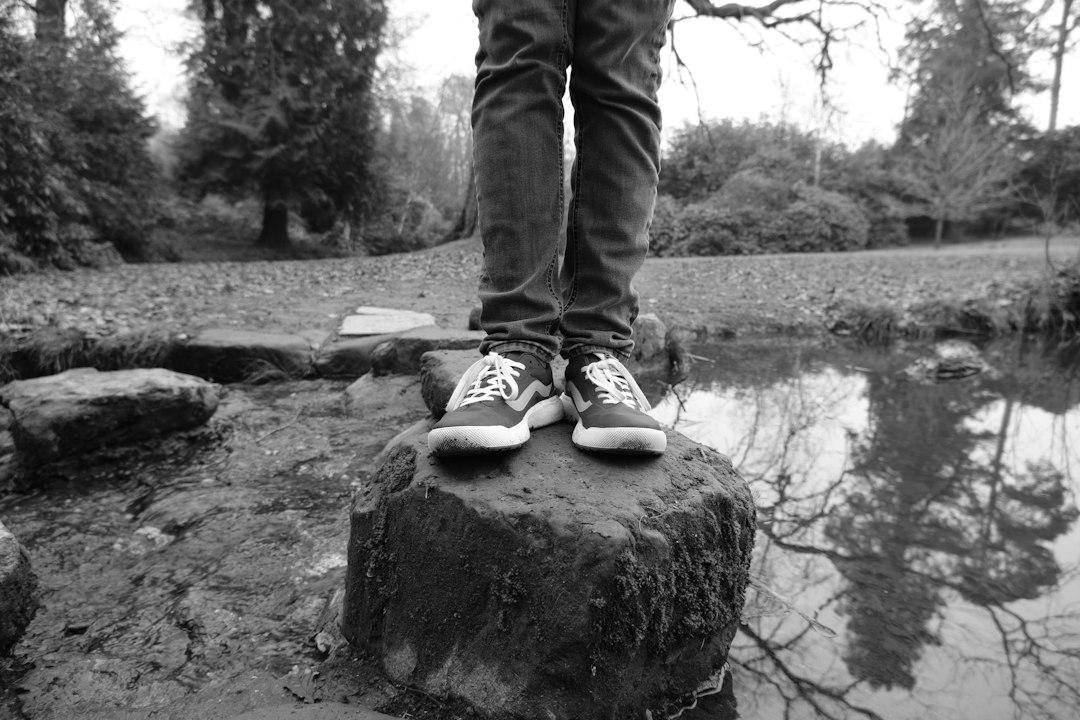 Person standing outdoors near water representing balance, activity, and mental wellness
