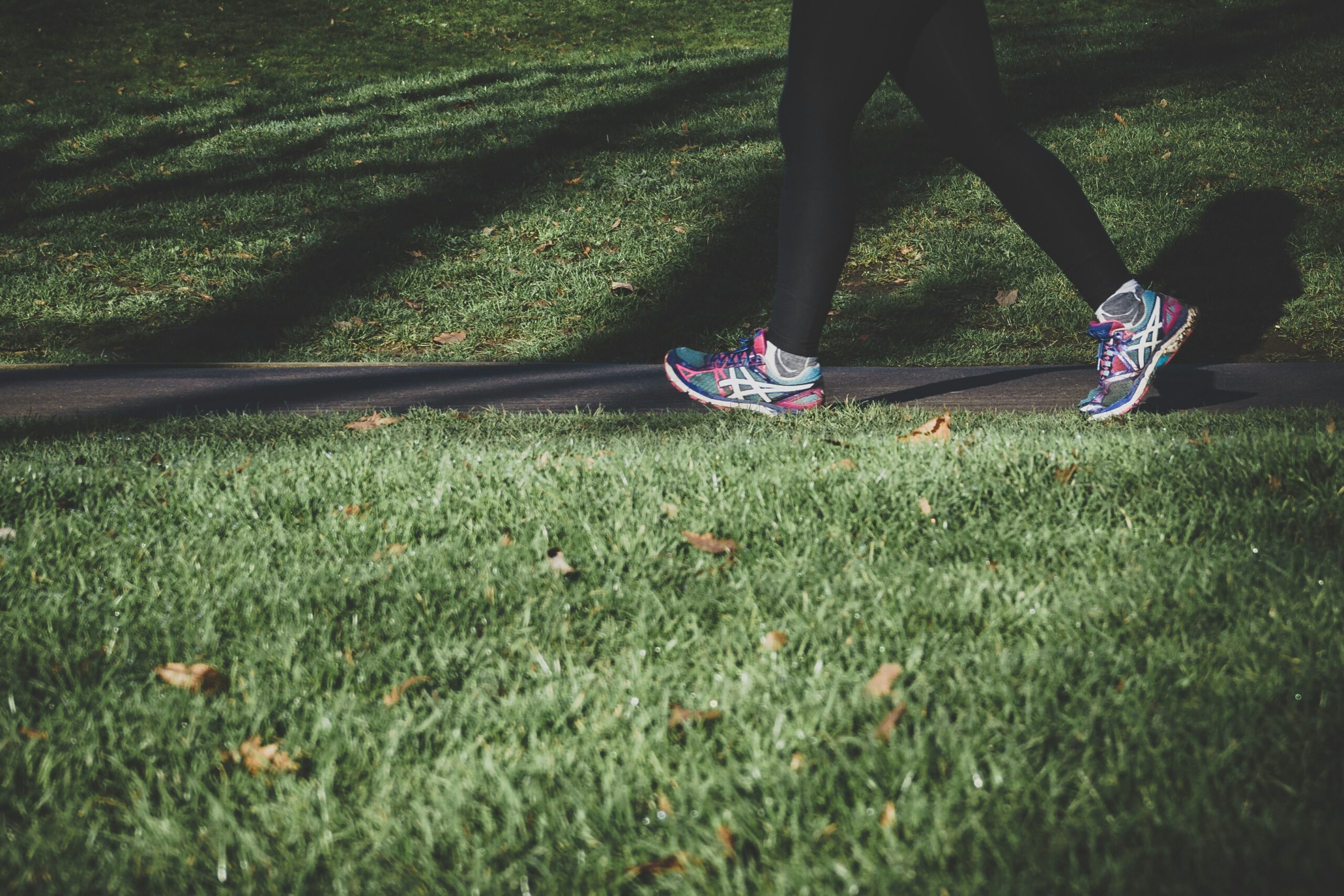 Woman exercising outdoors in a park representing movement, mood, and mental wellness