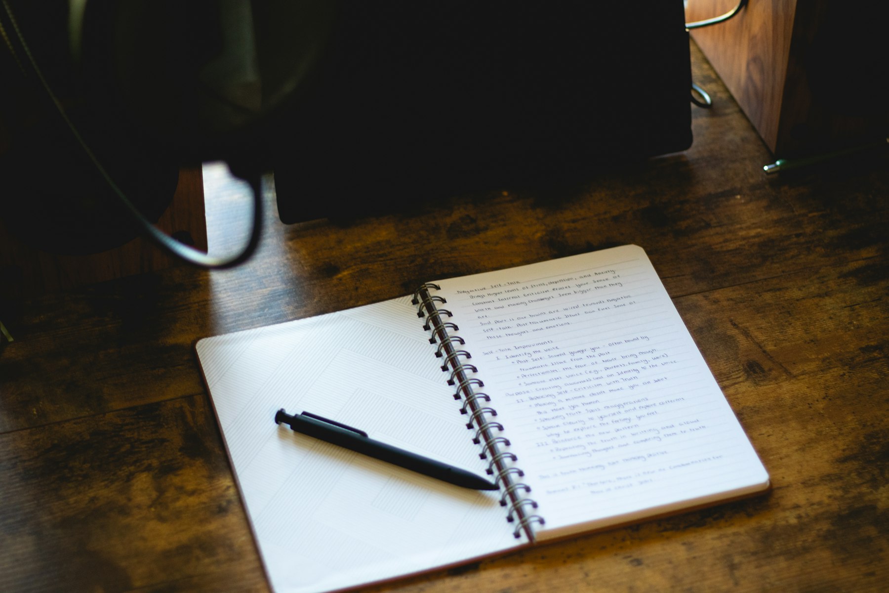 Open notebook and pen representing reflection, planning and organization.