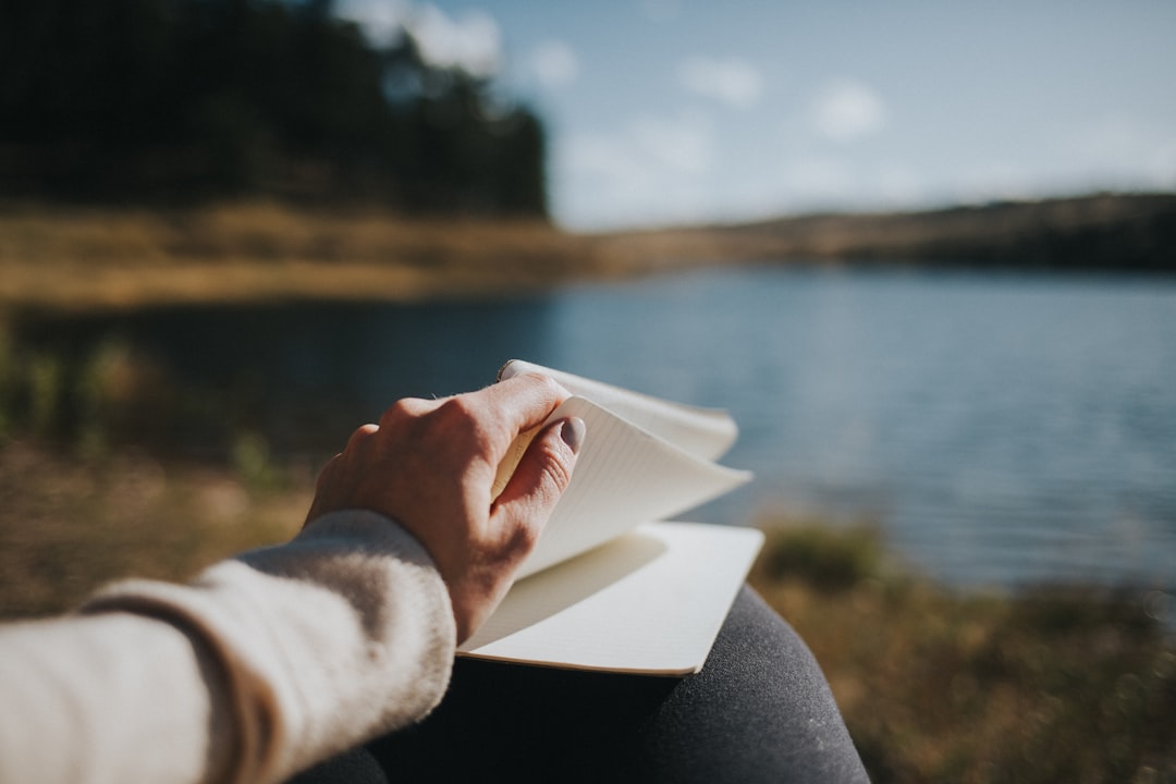 Person holding a book or journal representing reflection and building a replacement coping pattern